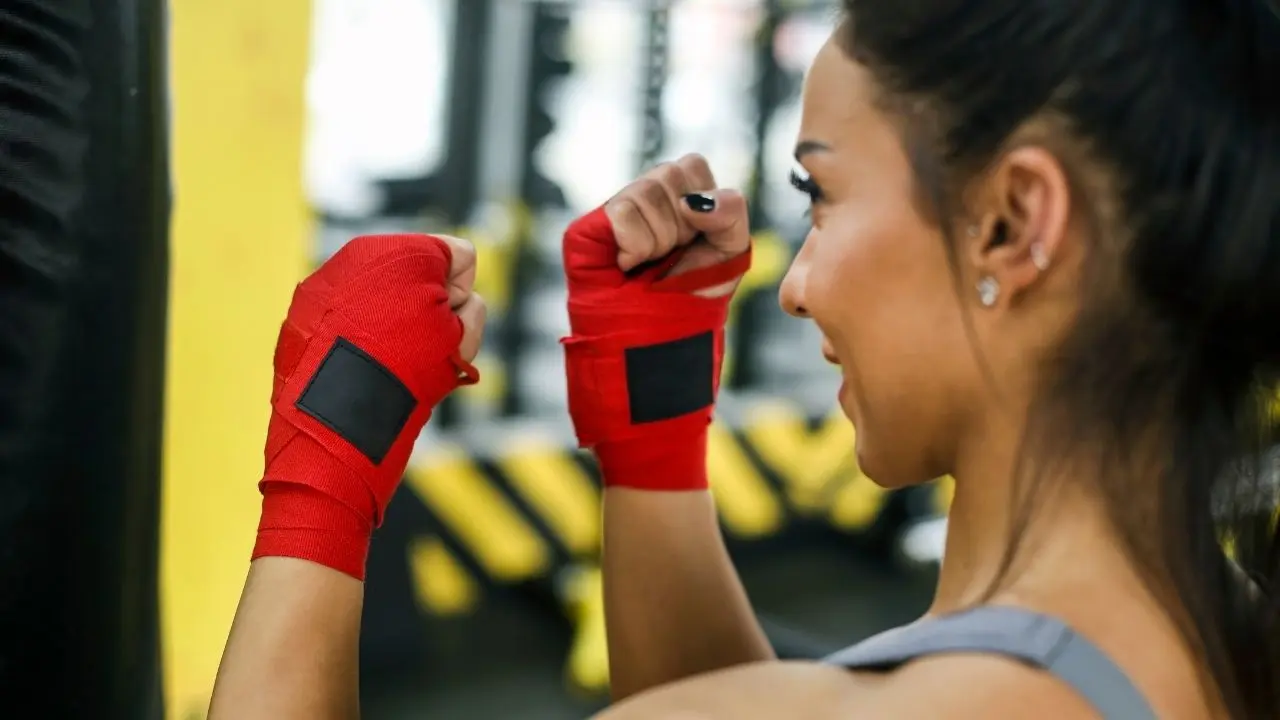 mulher se preparando para praticar kickboxing e melhorar o seu corpo