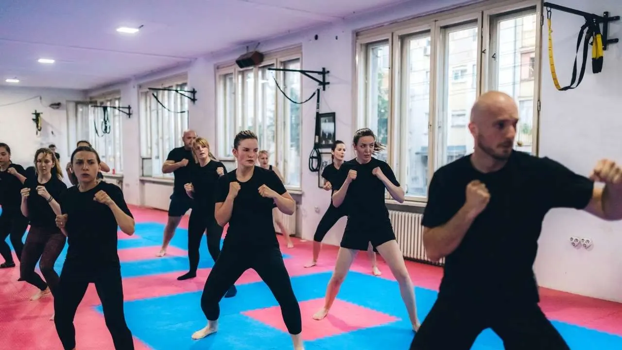 Turma praticando kickboxing em aula coletiva